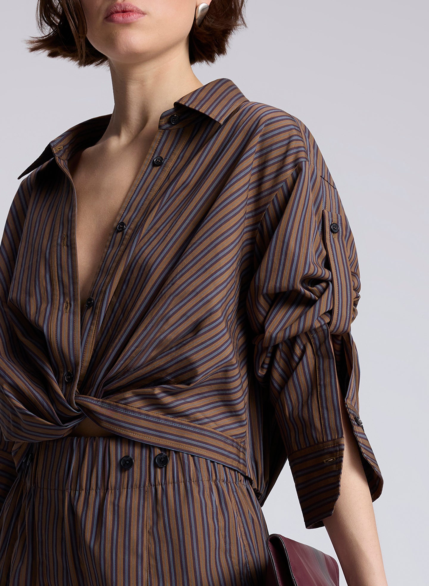 woman wearing brown button down shirt and matching set brown striped pants