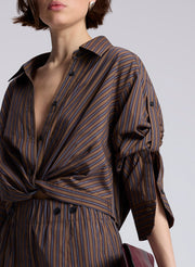 woman wearing brown button down shirt and matching set brown striped pants