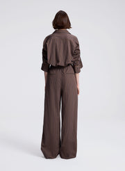 woman wearing brown button down shirt and matching set brown striped pants