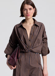 woman wearing brown stiped shirt and matching brown striped pants