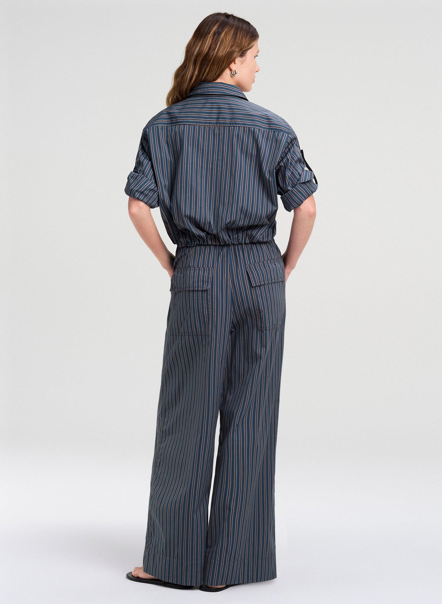 Woman wearing a gray pinstripe outfit on a white background