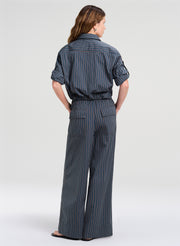 Woman wearing a gray pinstripe outfit on a white background
