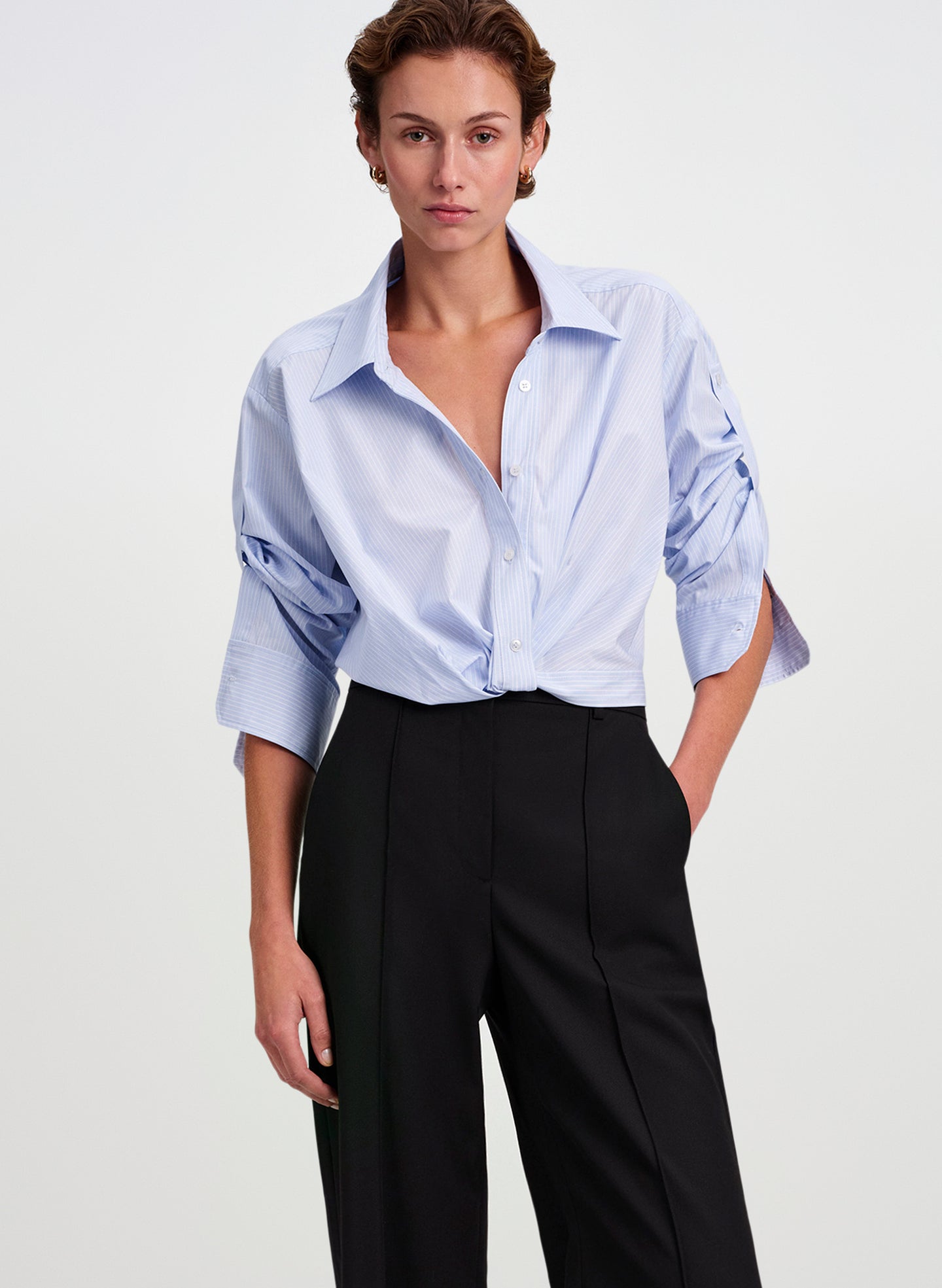 woman wearing blue striped shirt and black pants