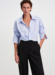 woman wearing blue striped shirt and black pants