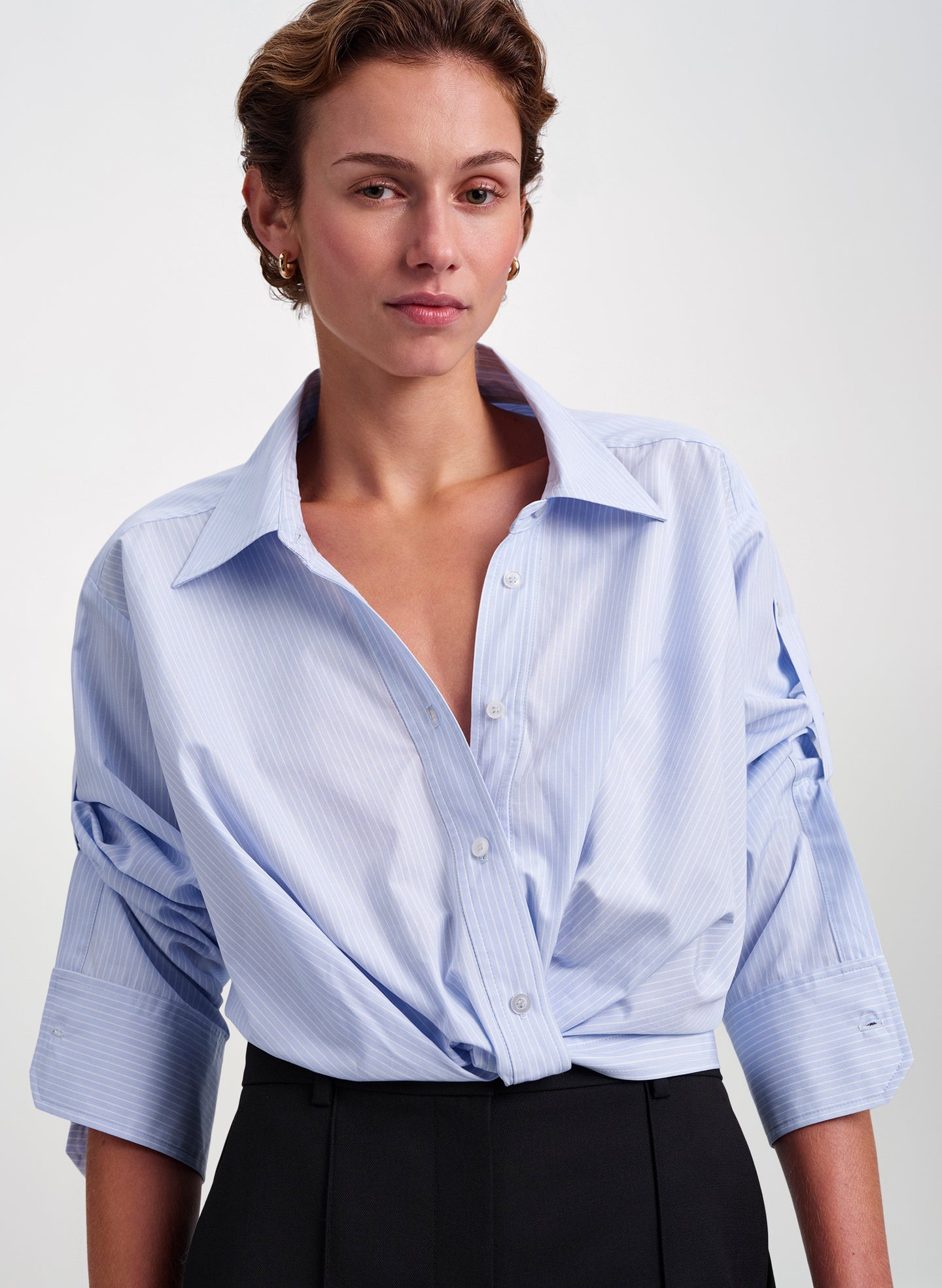 woman wearing blue striped shirt and black pants