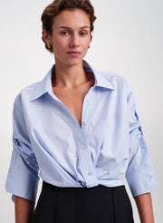 woman wearing blue striped shirt and black pants