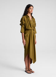 woman wearing olive green shirt and matching draped olive green midi skirt