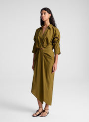 woman wearing olive green shirt and matching draped olive green midi skirt