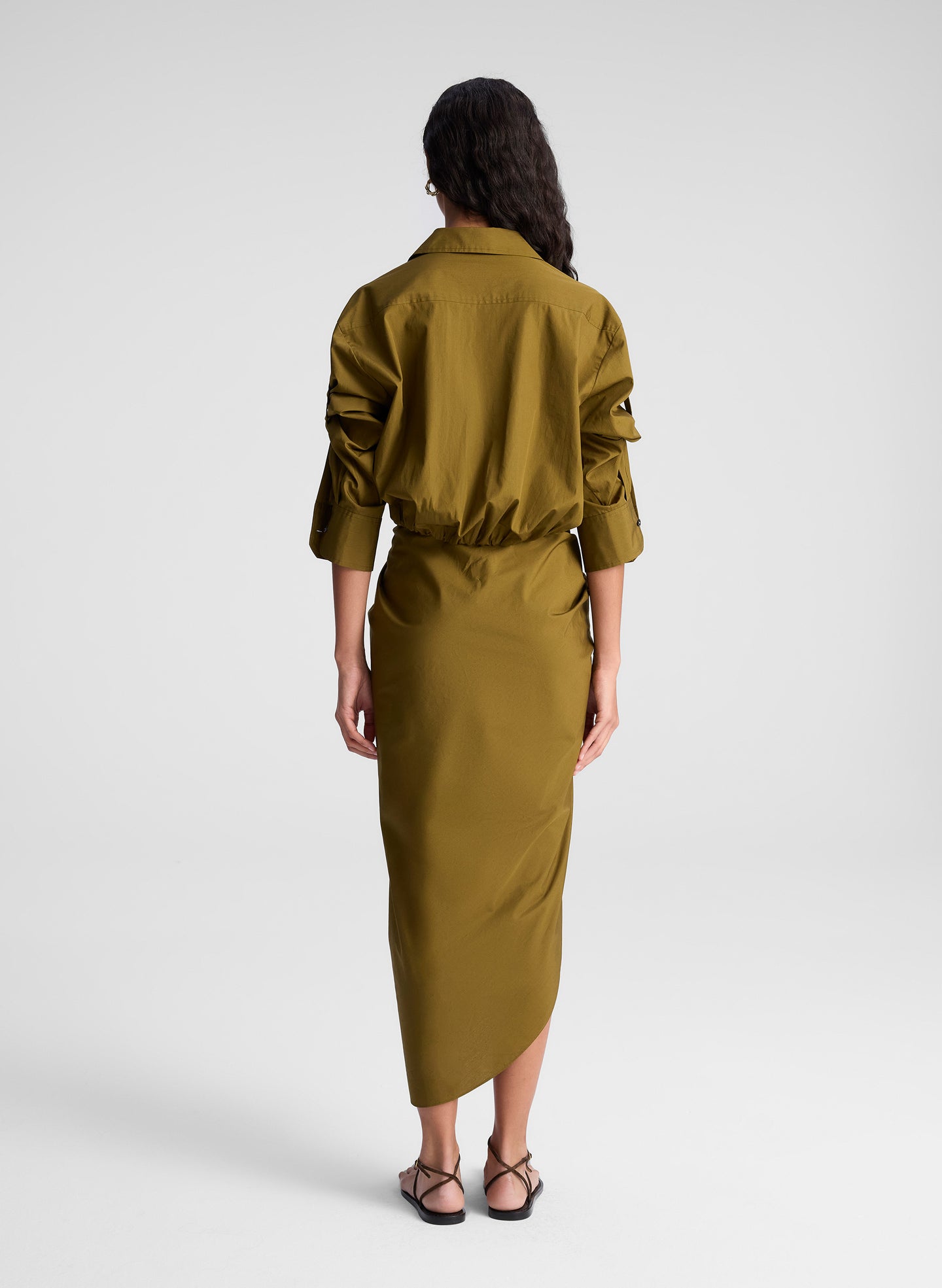 woman wearing olive green shirt and matching draped olive green midi skirt