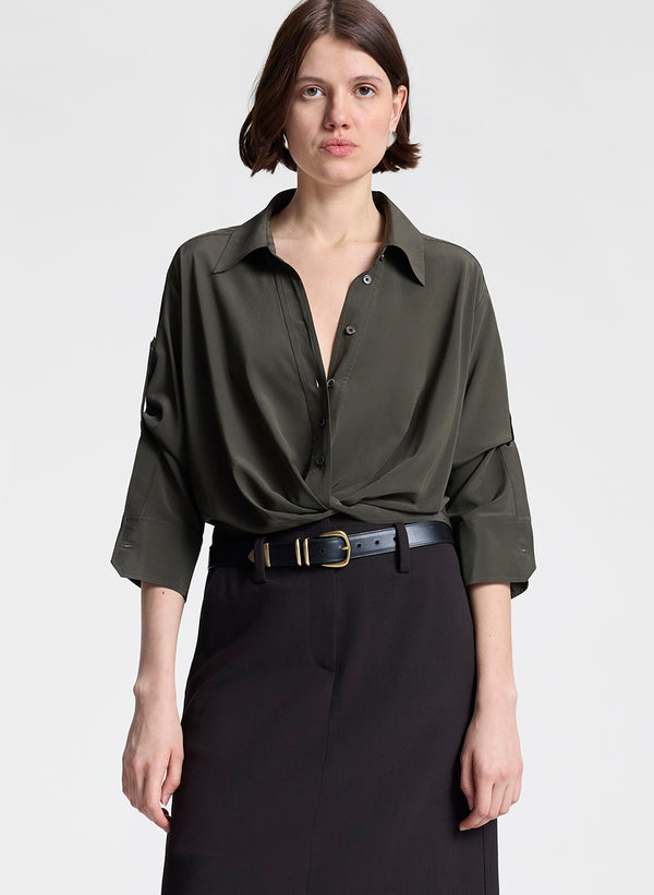 Woman wearing a green shirt and dark brown skirt on a white background