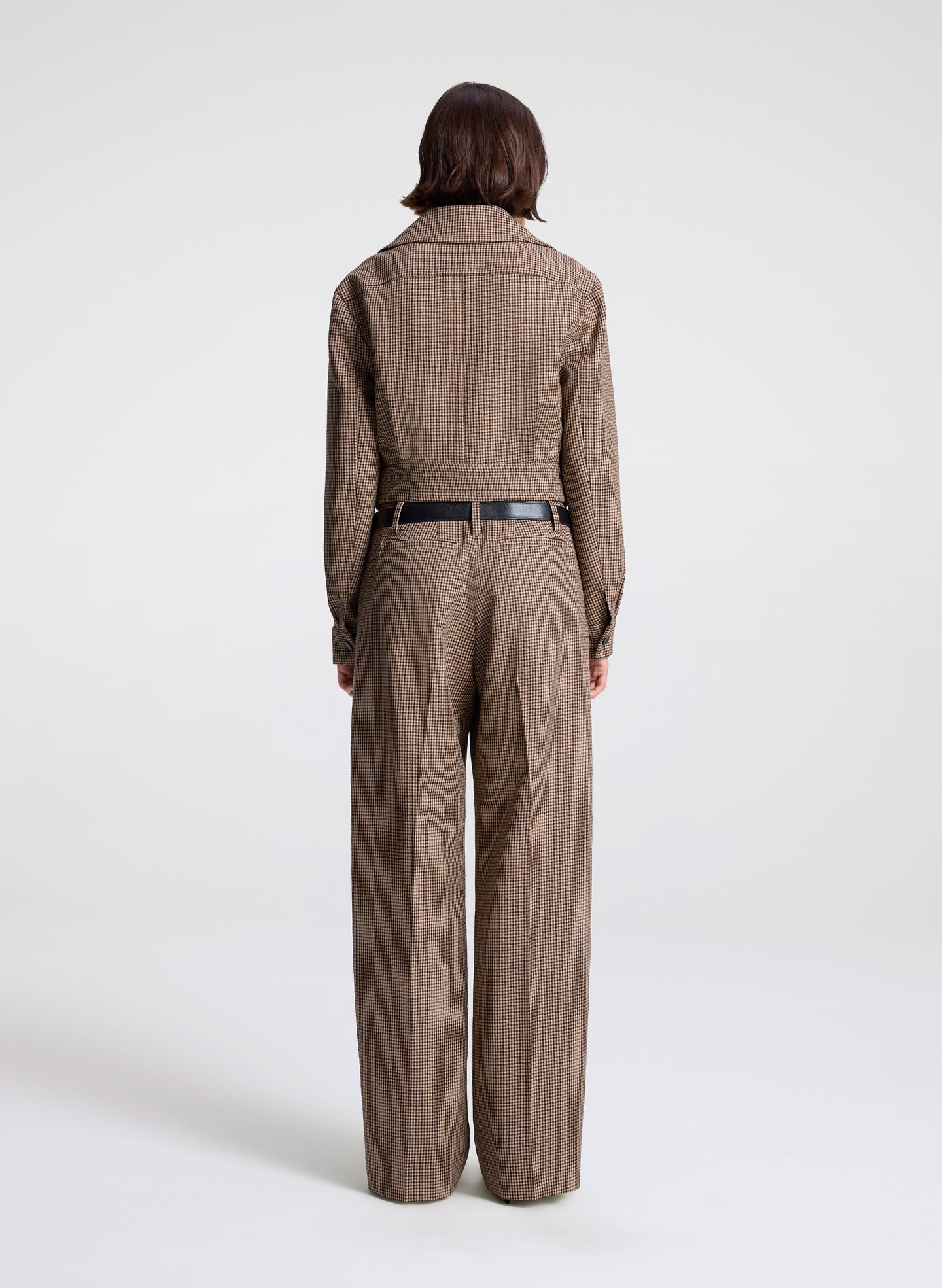 woman wearing  a brown checkered jacket and matching pants  