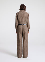 woman wearing  a brown checkered jacket and matching pants  