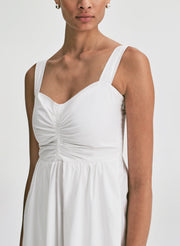 Woman wearing a white midi dress against a plain background