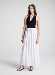 woman wearing black haler bodysuit and white maxi skirt