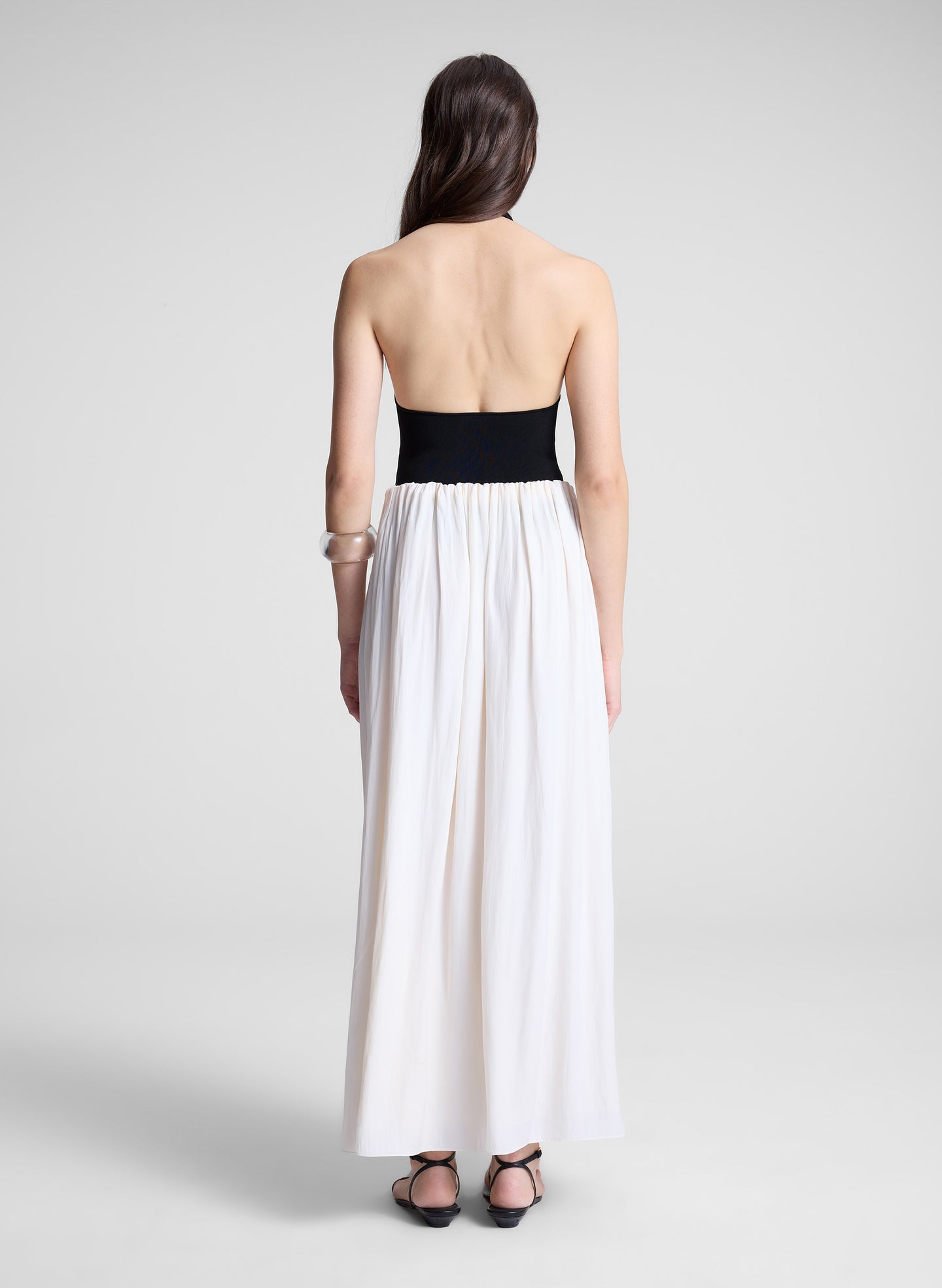 woman wearing black haler bodysuit and white maxi skirt