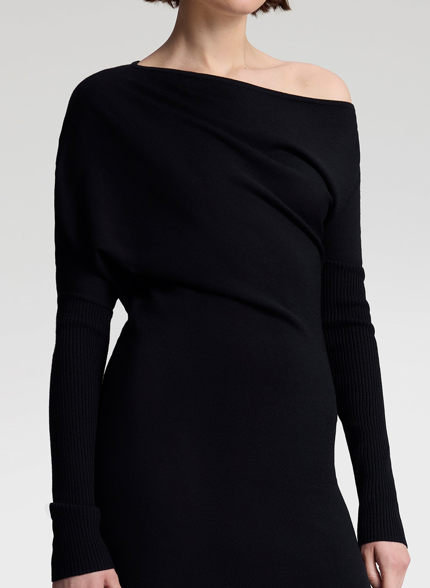 Black off-shoulder dress on a plain background