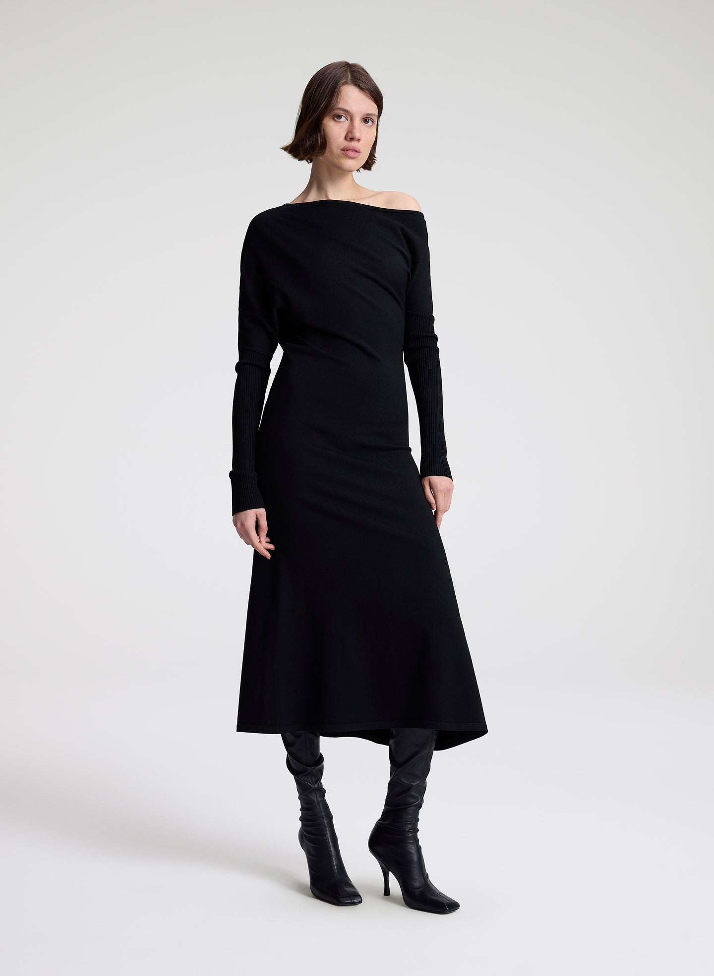 Woman wearing a black off-shoulder dress on a white background