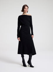 Woman wearing a black off-shoulder dress on a white background