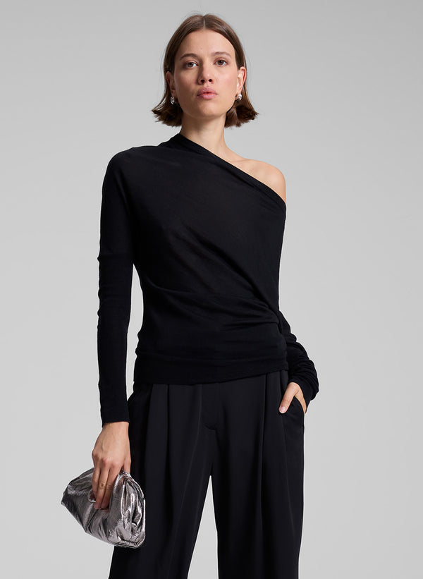 woman wearing black off one shoulder long sleeve top and black pants