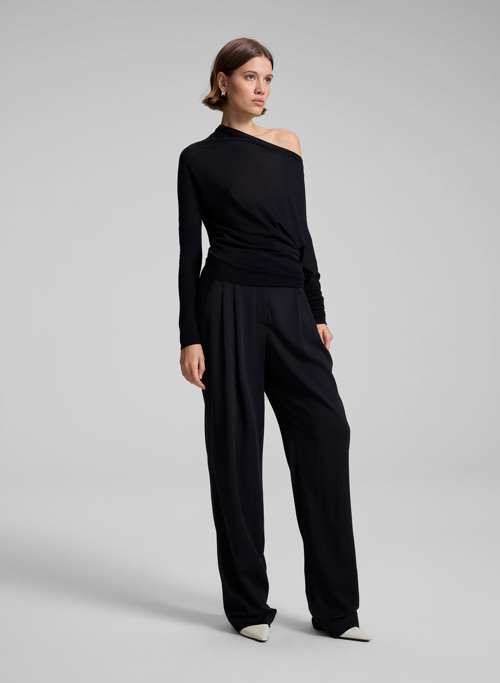 woman wearing black off one shoulder long sleeve top and black pants