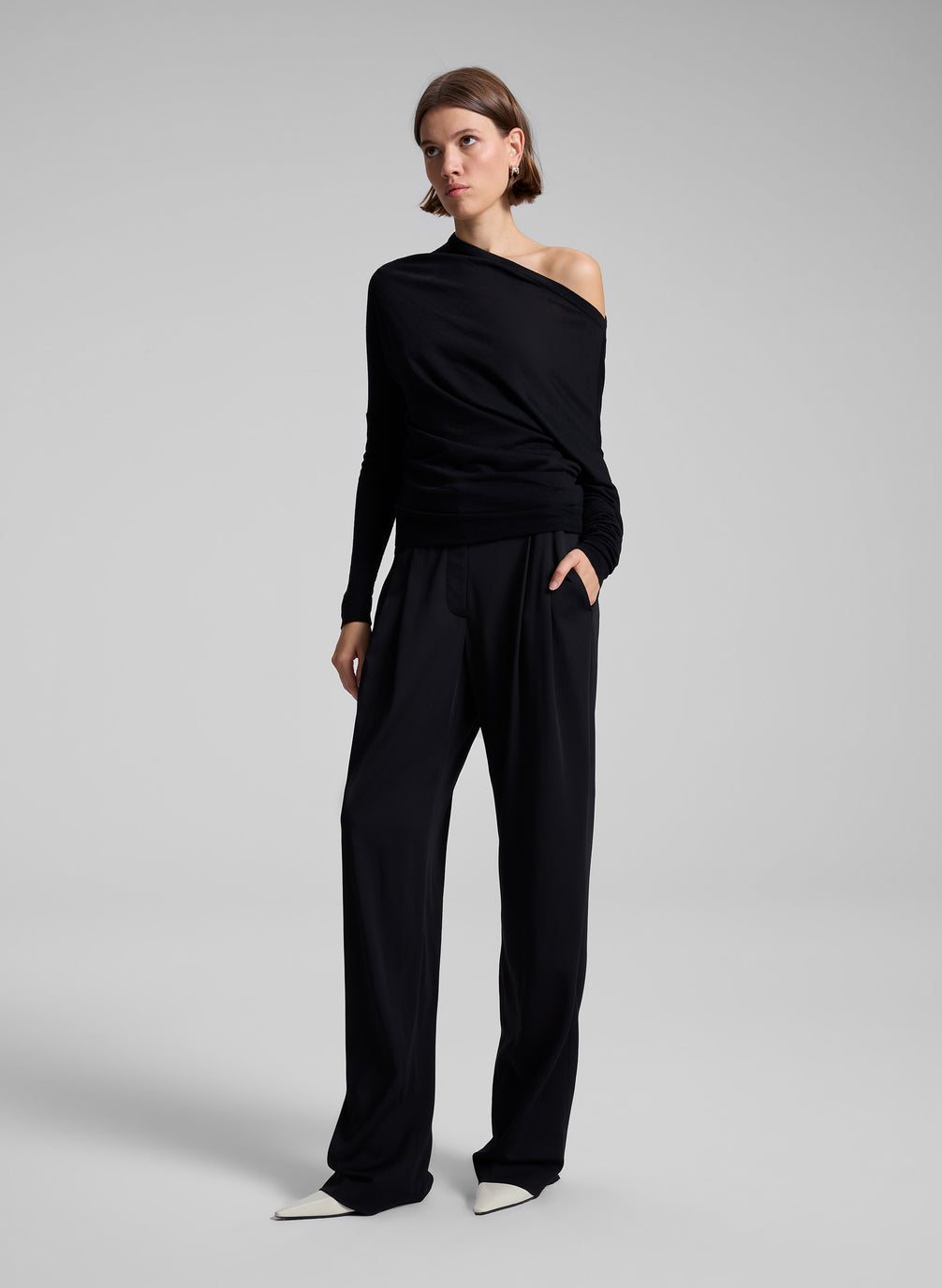 woman wearing black off one shoulder long sleeve top and black pants