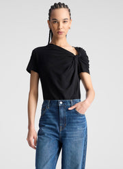 woman wearing black asymmetric draped tee shirt and jeans