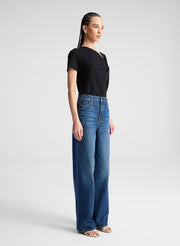 woman wearing black asymmetric draped tee shirt and jeans