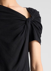 woman wearing black asymmetric draped tee shirt and jeans