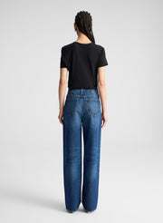 woman wearing black asymmetric draped tee shirt and jeans