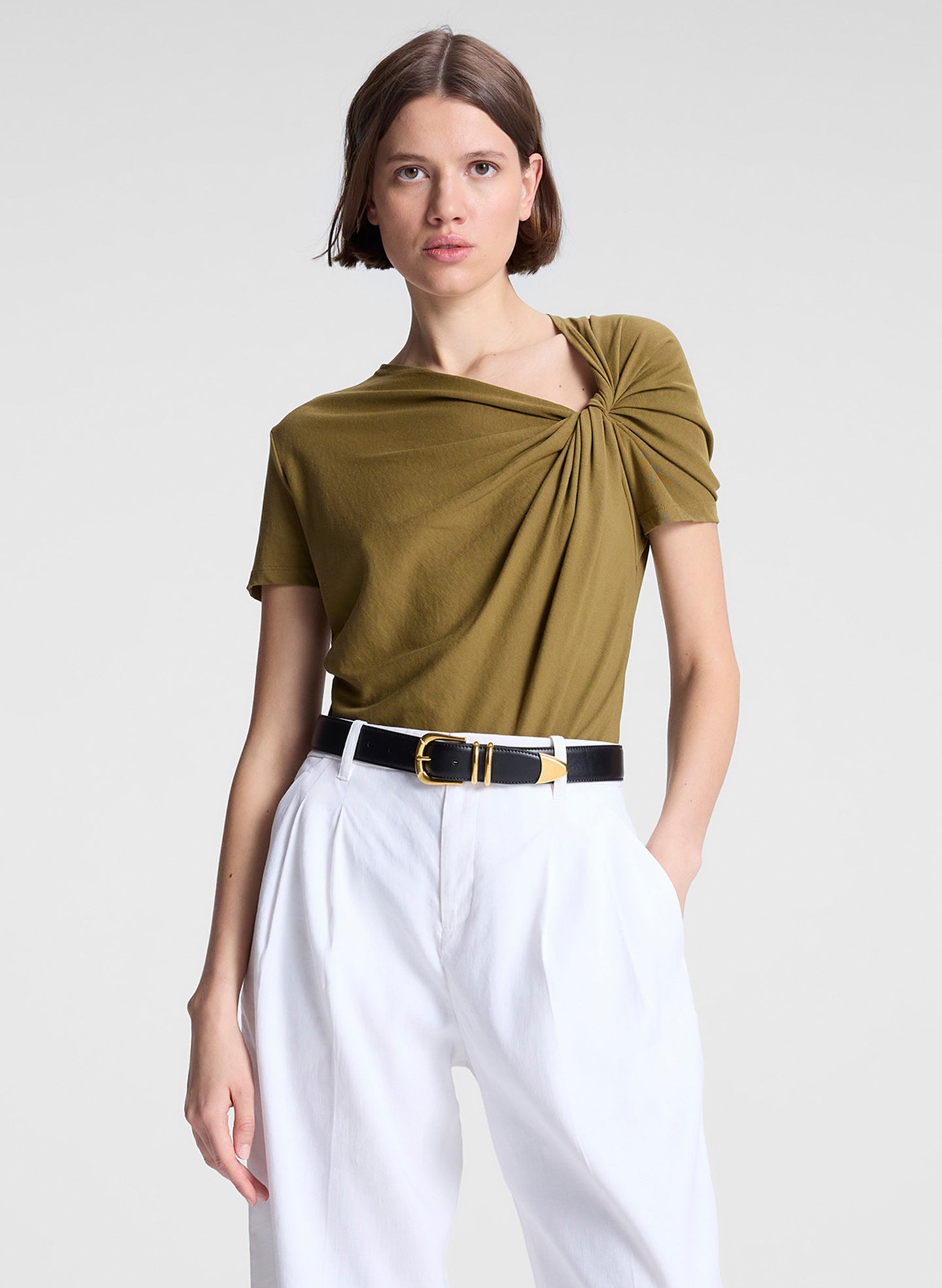 woman wearing green asymmetric tee and beige pants