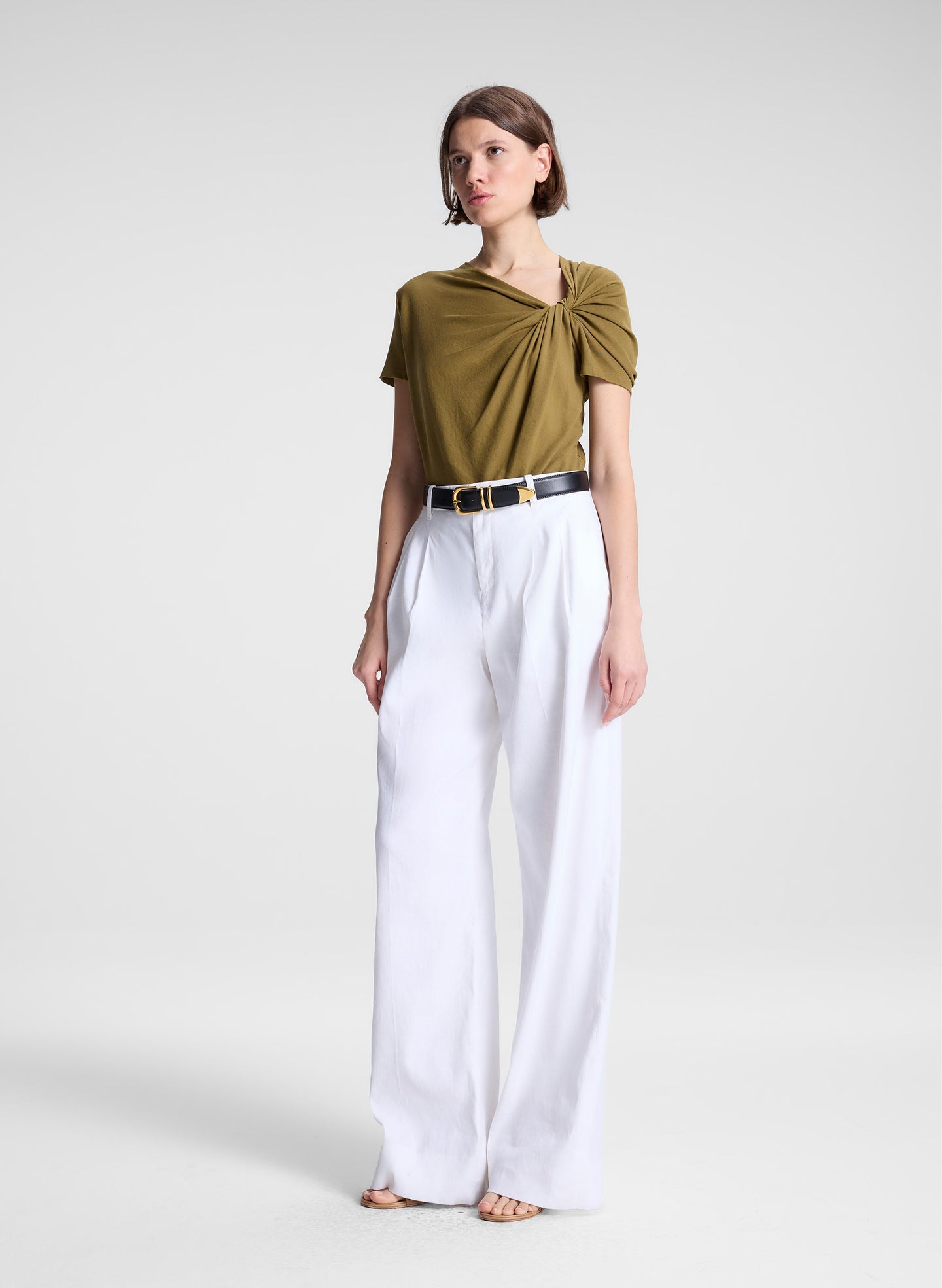 woman wearing green asymmetric tee and beige pants