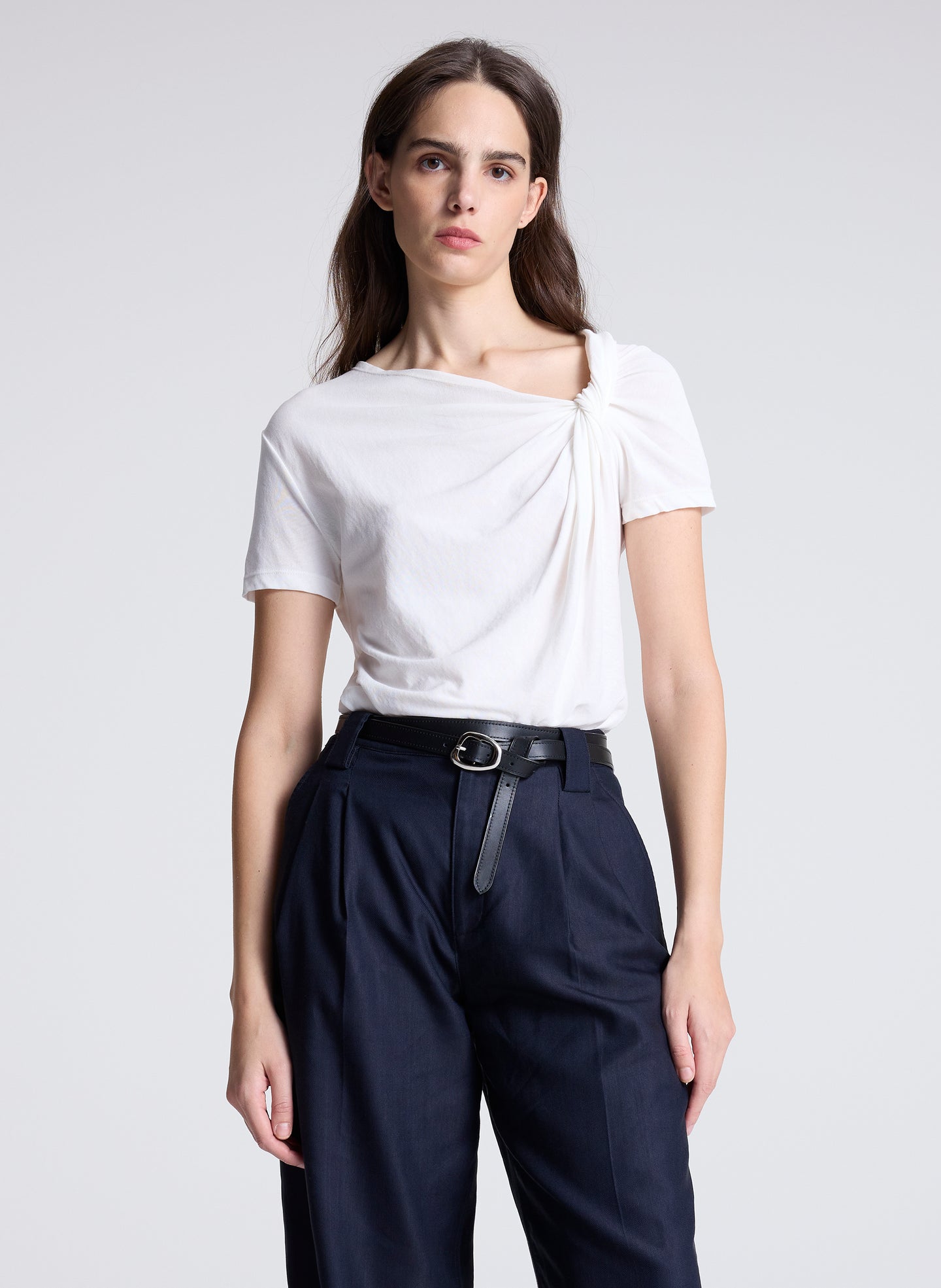 woman wearing white asymmetric draped tee and navy blue pants