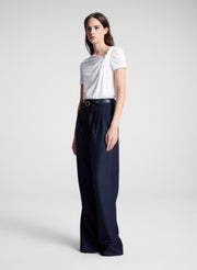 woman wearing white asymmetric draped tee and navy blue pants