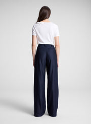 woman wearing white asymmetric draped tee and navy blue pants