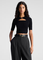 woman wearing black open back fine gauge voile knit top and black linen pants