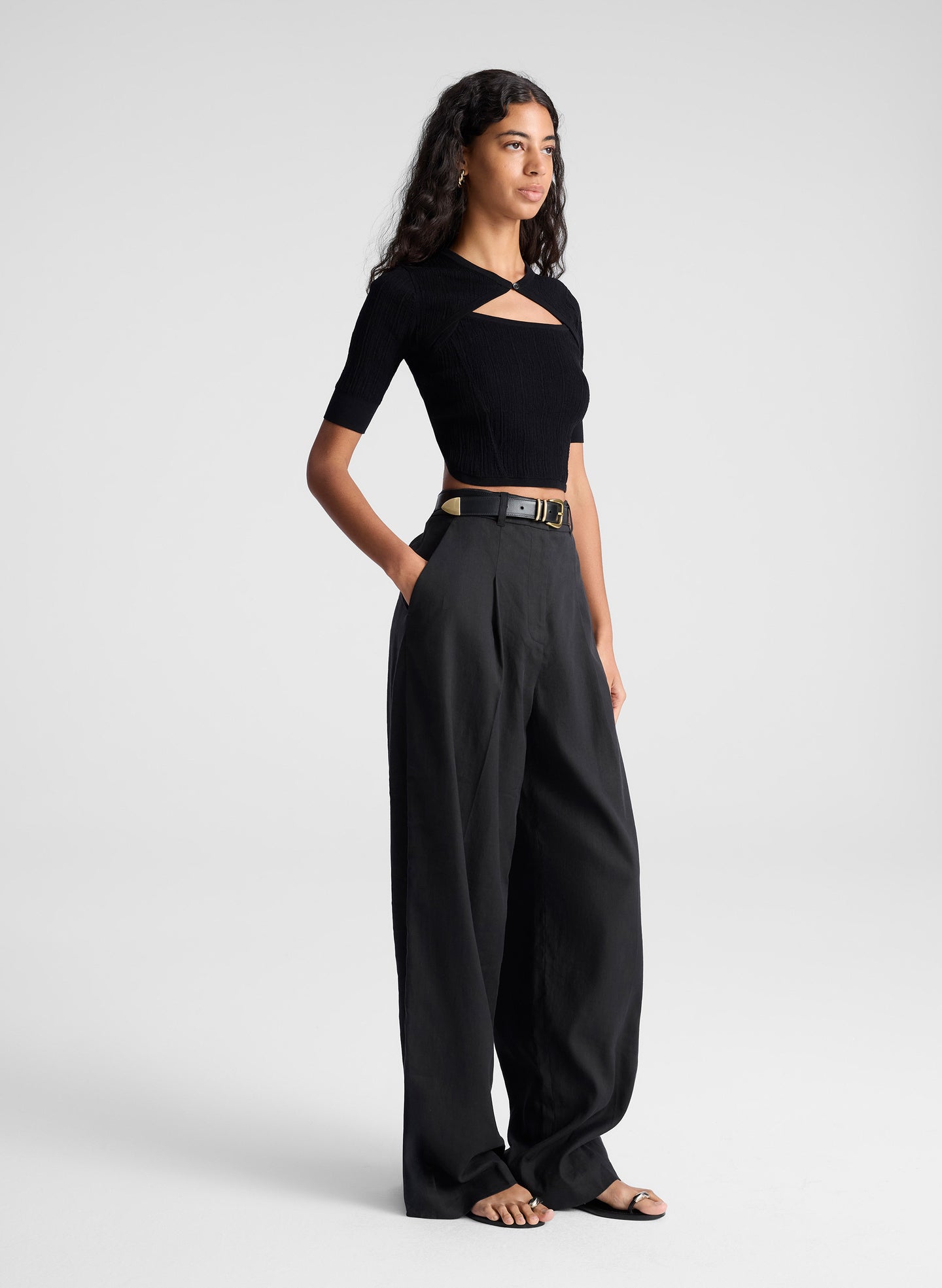 woman wearing black open back fine gauge voile knit top and black linen pants