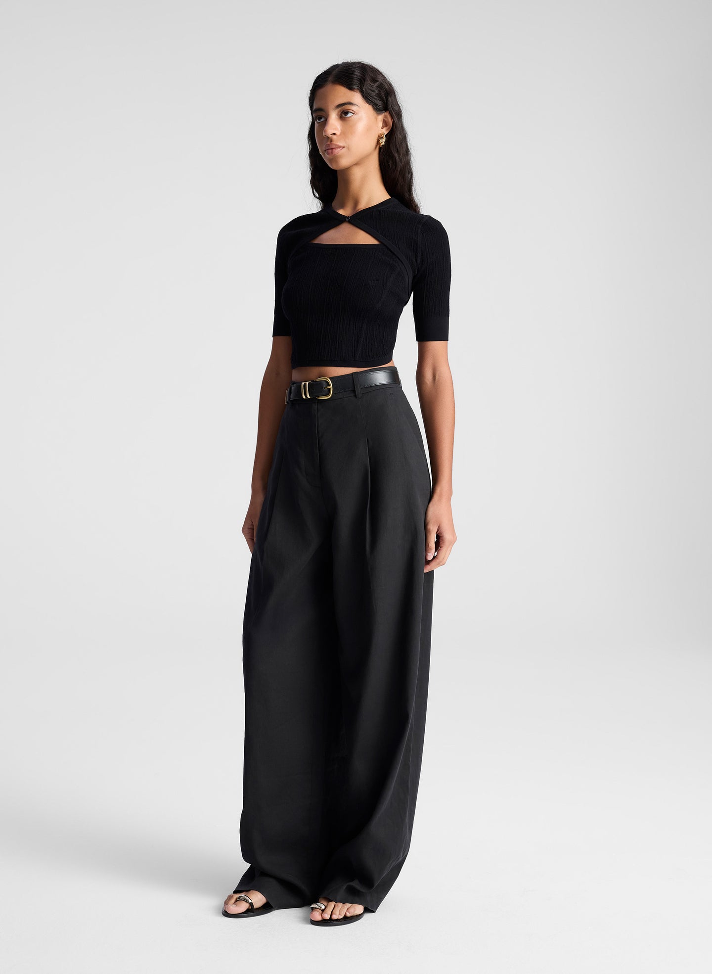 woman wearing black open back fine gauge voile knit top and black linen pants