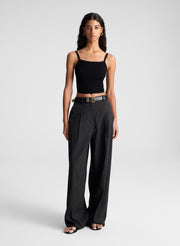 woman wearing black open back fine gauge voile knit top and black linen pants