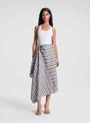 woman wearing white fine gauge tank top and striped midi skirt