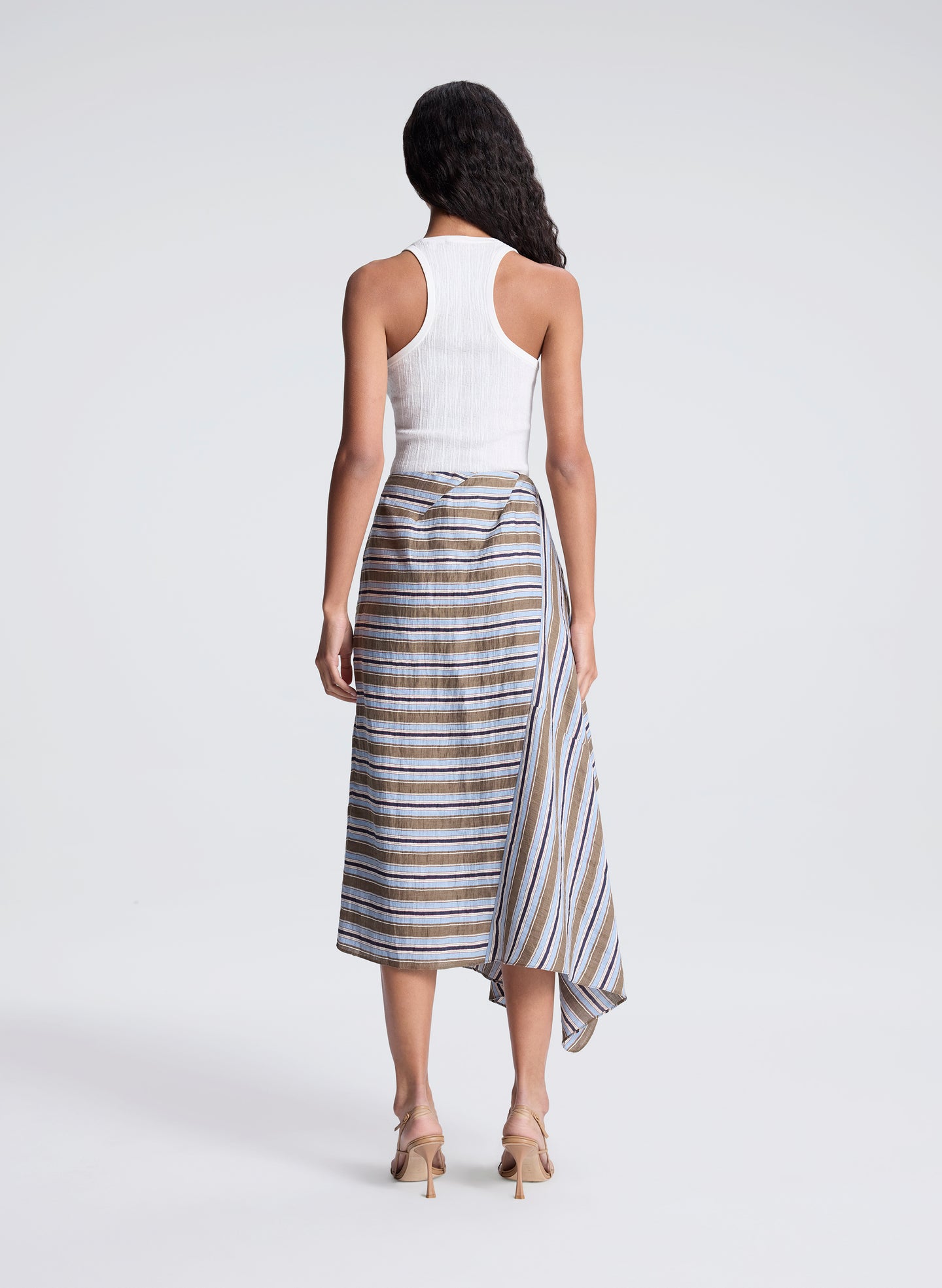 woman wearing white fine gauge tank top and striped midi skirt