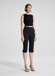 woman wearing black cropped sleeveless fine gauge voile knit top and black capri pants