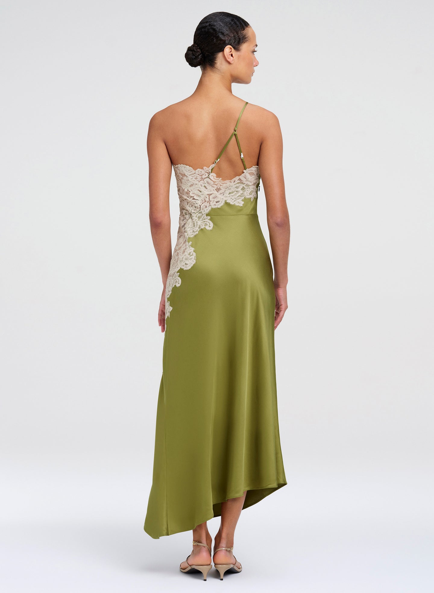 Woman wearing a green midi dress with lace details on a white background