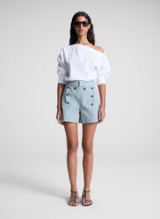 woman wearing white off shoulder top and light blue shorts