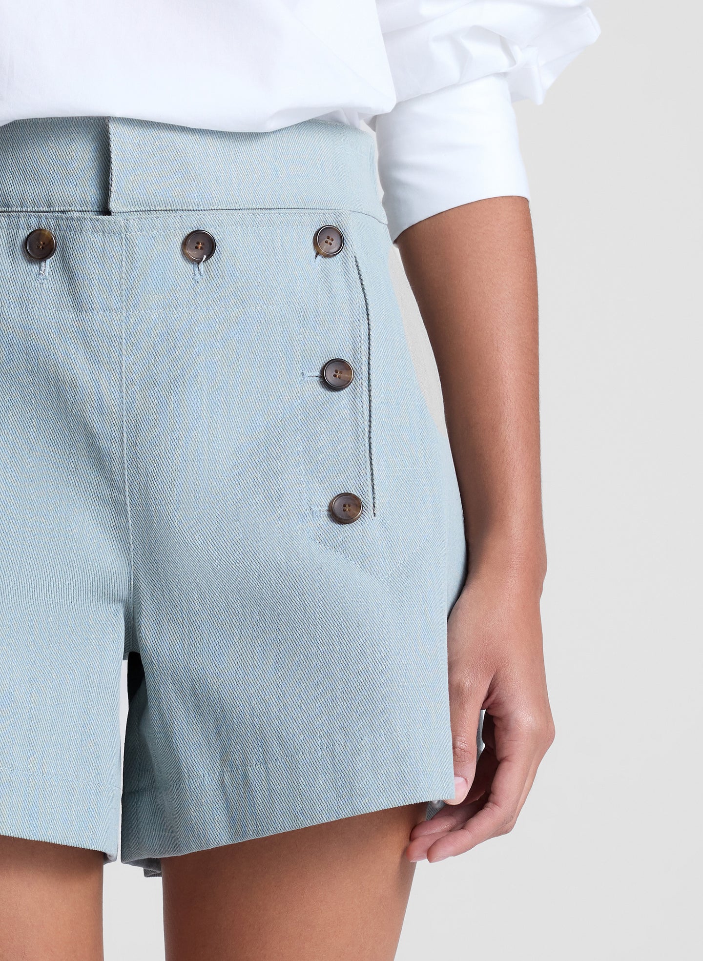 woman wearing white off shoulder top and light blue shorts