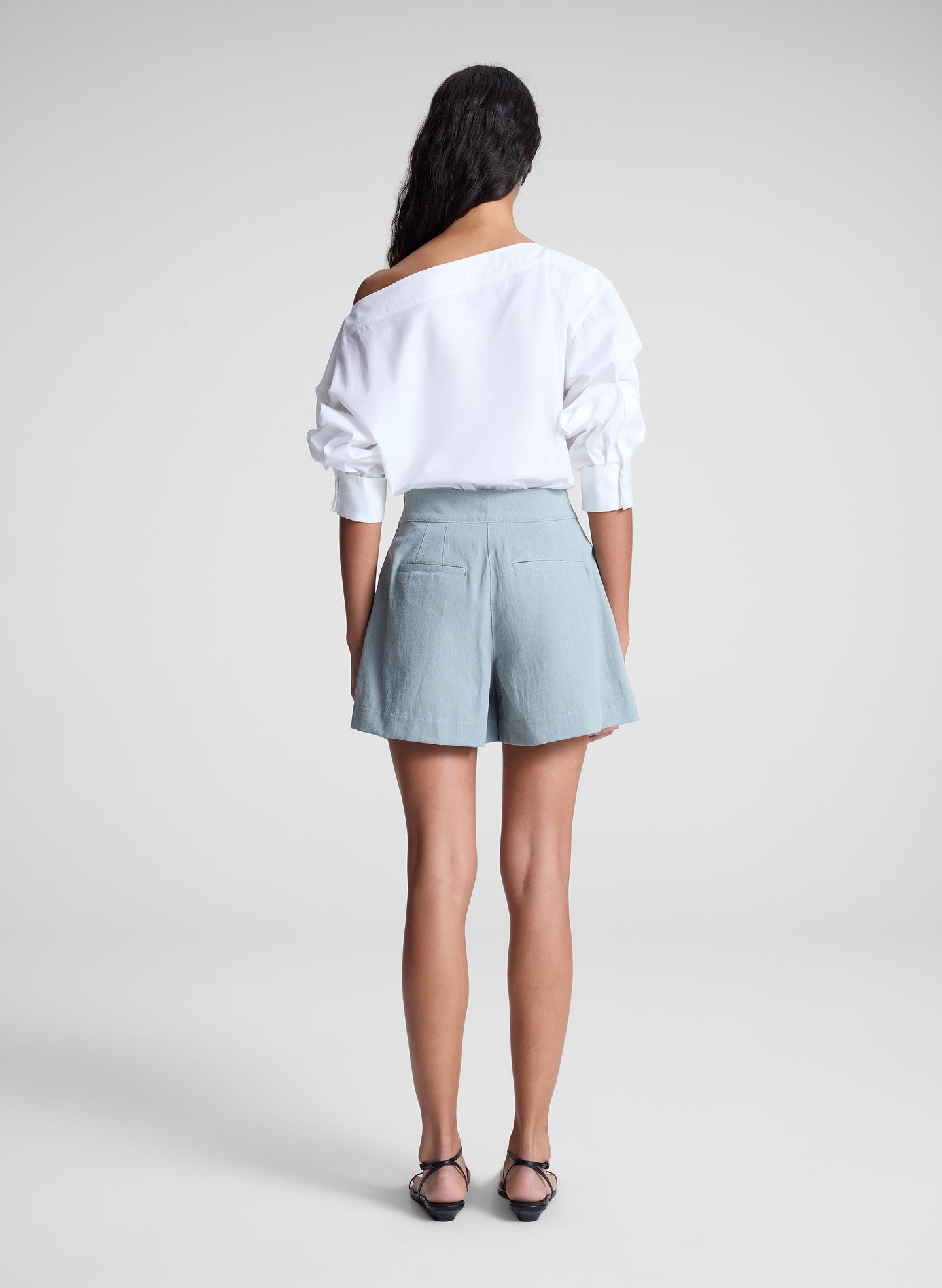 woman wearing white off shoulder top and light blue shorts