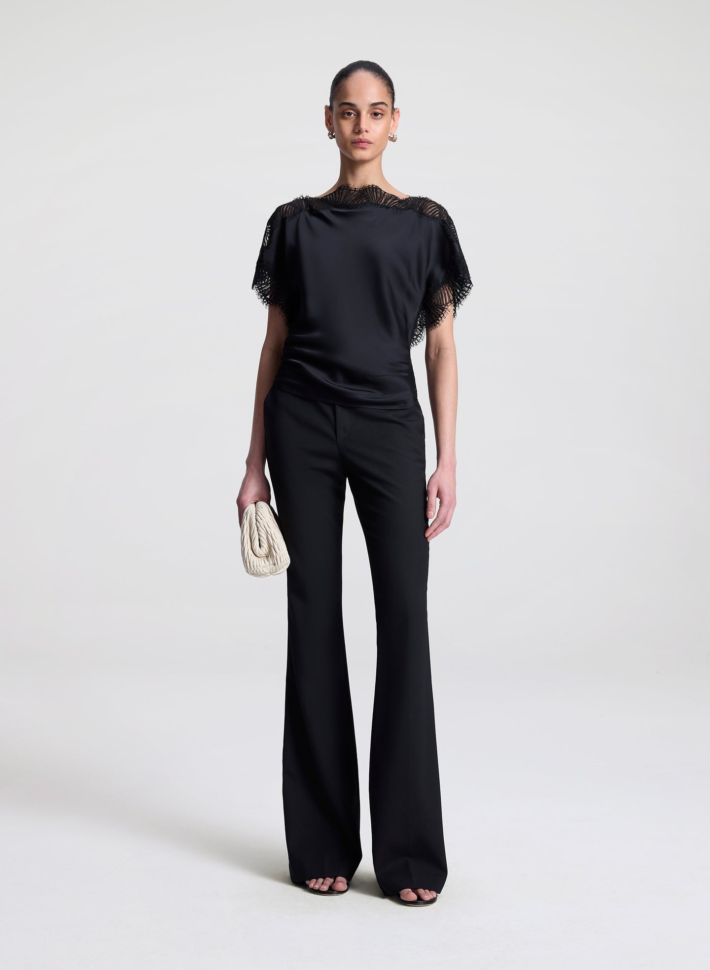 woman wearing black satin and lace top with black pants