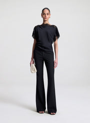 woman wearing black satin and lace top with black pants