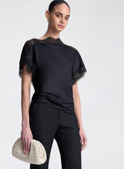 woman wearing black satin and lace top with black pants