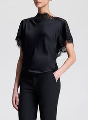 woman wearing black satin and lace top with black pants