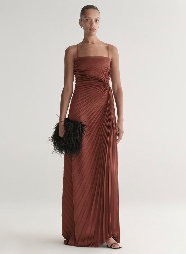 woman wearing strapless pleated gown in a rust hue